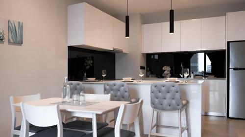 a kitchen and dining room with a table and chairs at Suites Apartment By Star Residences in Kuala Lumpur