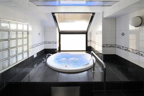 Water Hotel Mw (Love Hotel) في سايتاما: حمام مع حوض استحمام مع نافذة