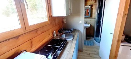 Il comprend une cuisine équipée d'une cuisinière. four supérieur à côté d'une fenêtre dans l'établissement Studio éco-construit - climatisation & parking, à Nanteuil-lès-Meaux