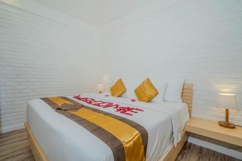 a white bedroom with a bed with red flowers on it at Villa Naynaka in Seminyak