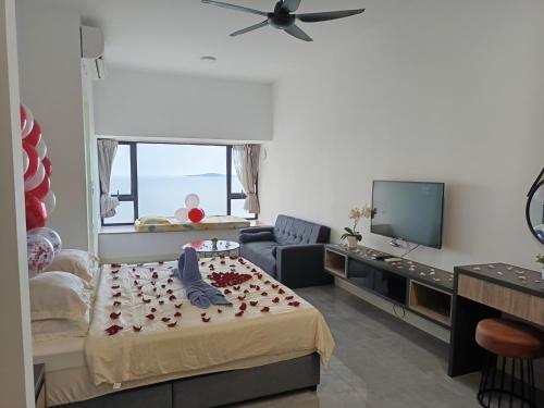 Una sala de estar con una cama y un televisor. en Imperio Homestay by ENM GROUP, en Melaka