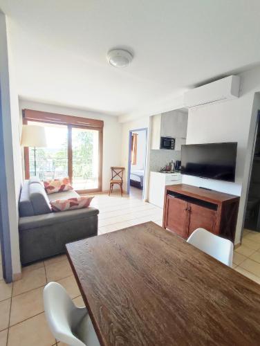 un salon avec une table et un canapé dans l'établissement Appartement avec grande terrasse au centre ville d'Uzès, à Uzès