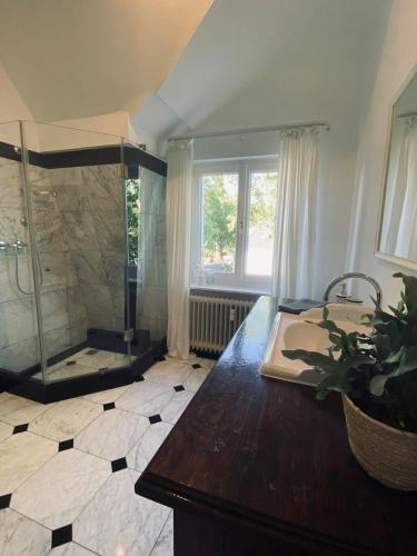 a large bathroom with a shower and a wooden table at Design-Loft mit 2 Balkonen am Stadtwald - 20 min zur Messe Düsseldorf in Krefeld
