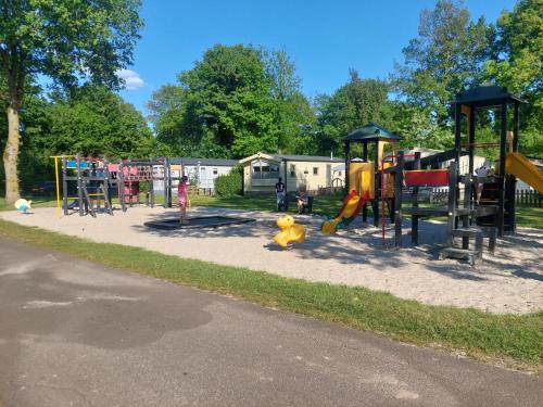 a park with a playground with slides and play equipment at Sfeervol, kindvriendelijk familie chalet nr 74 aan speeltuin - De Pallegarste in Mariënberg