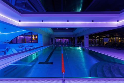 a swimming pool in a building with blue lights at Molfar Resort Hotel & SPA Карпати in Shaian