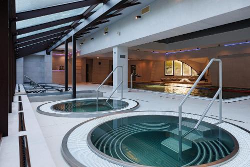 two hot tubs in the middle of a building at Molfar Resort Hotel & SPA Карпати in Shaian