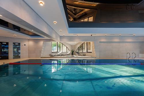 a large swimming pool in a building with a large ceiling at Molfar Resort Hotel & SPA Карпати in Shaian