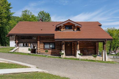 a wooden house with a red roof at Molfar Resort Hotel & SPA Карпати in Shaian