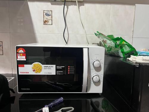 a microwave sitting on top of a counter at MIA guests house in Nilai