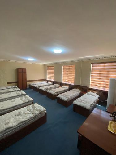 ein großes Zimmer mit vielen Betten und Fenstern in der Unterkunft Hostel INN Andijan in Andizhan