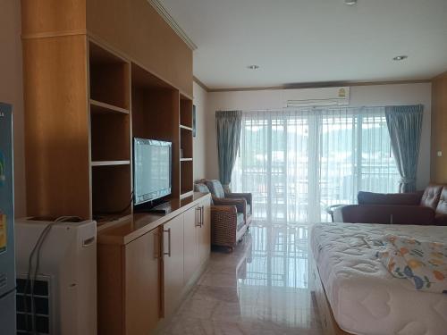 a room with a bed and a tv and a living room at Baan Klang condo in Hua Hin