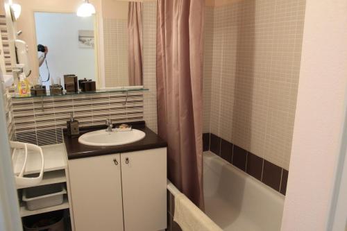 une salle de bain avec un lavabo et une baignoire dans l'établissement villa soleil au bord du canal du midi, à Homps