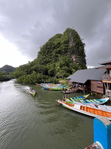 a group of boats are docked on a river at Cottage Pier 2 of Rammang-Rammang in Kasijala
