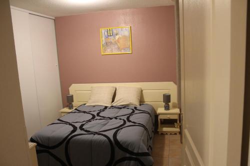 une chambre avec un lit et deux tables de nuit dans l'établissement villa soleil au bord du canal du midi, à Homps