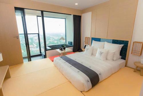 a bedroom with a large bed with a large window at Lynn Times Thanh Thuỷ hotspring-KS 35 tầng- My Home in Phú Thọ
