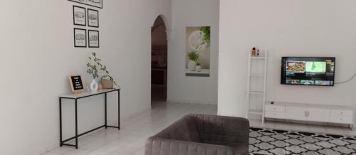 a living room with a couch and a tv at Tok Mek Homestay in Jertih