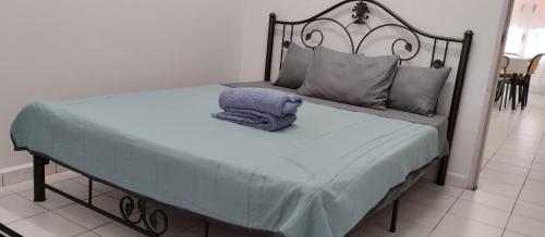 a bed with a blue pillow on top of it at Tok Mek Homestay in Jertih
