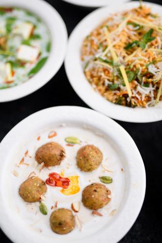 a table with three plates of food with meatballs at Best Western Plus Revanta Mcleod Ganj in Dharamshala