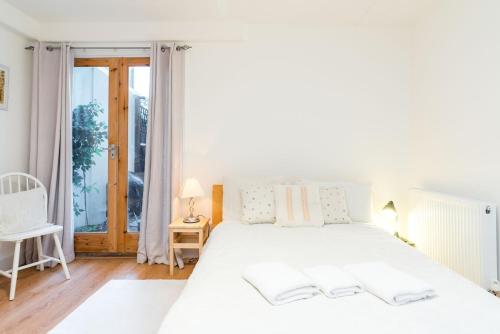 a white bedroom with a large white bed and a window at NEW Stylish 1 Bedroom Flat with Garden | London in London