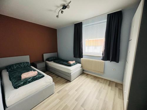 ein kleines Schlafzimmer mit einem Bett und einem Fenster in der Unterkunft Große Ferienwohnung mit Traumküche I 24 h Check in I Free Parking in Bielefeld