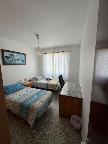 a hotel room with two beds and a table at La casita de Bécquer Habitaciones compartidas in Playa del Hombre