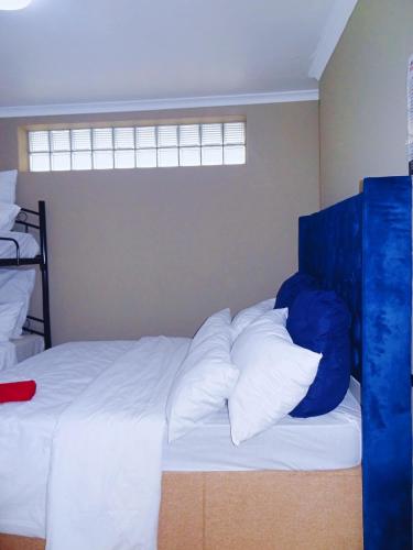 a bedroom with a bed with white sheets and pillows at BKaap2 Queens and Kings Guest House in Cape Town
