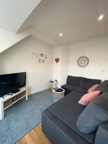 a living room with a couch and a flat screen tv at Apartment - Centre of Swanage Stunning Sea views in Swanage