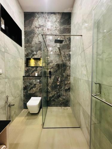 a bathroom with a glass shower with a toilet at Singaras Coffee Country in Masinagudi