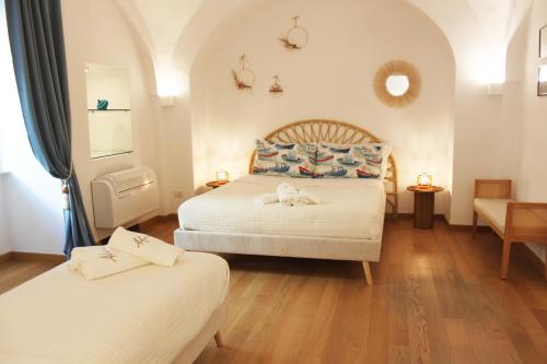a bedroom with two beds and a table at Ademè dimora di charme in Monopoli