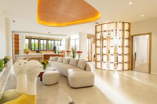 a large living room with a white couch and chairs at Meraki Villa Đà Lạt in Khu Chi Lăng