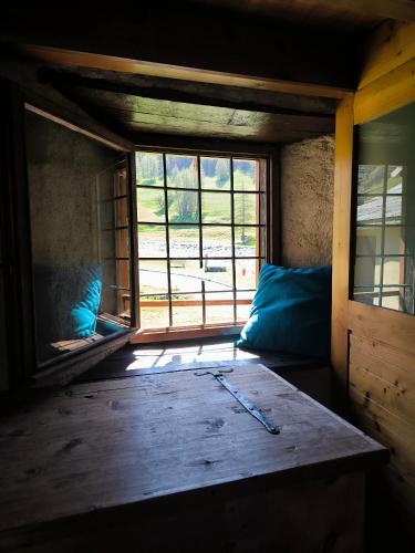 a room with a large window and a wooden table at Chalet d'alpage au coeur du Parc naturel du Queyras - exceptionnel in Valpreveyre