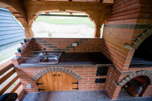 an outdoor kitchen with a sink and a brick oven at Cabana Ulici A-frame in Bîrsana