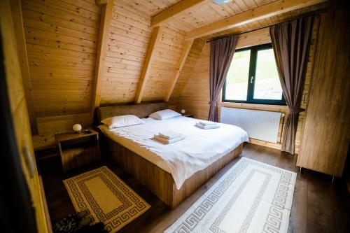 a bedroom with a bed in a wooden cabin at Cabana Ulici A-frame in Bîrsana