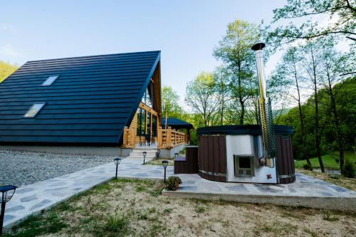 a home with a large building with a gazebo at Cabana Ulici A-frame in Bîrsana