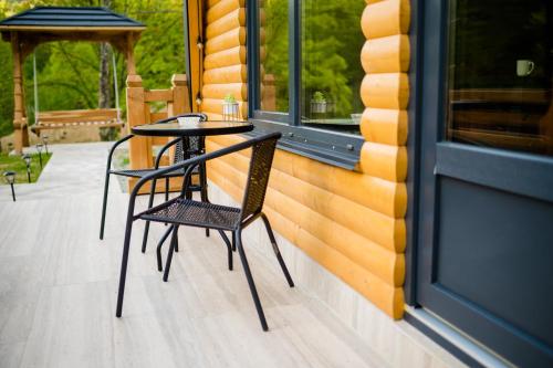 a table and chair on the porch of a house at Cabana Ulici A-frame in Bîrsana