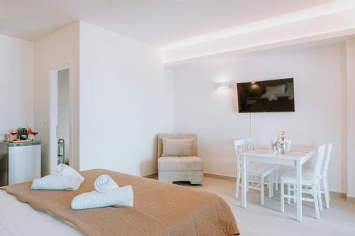 a white room with a bed and a table with a chair at Sivota Seafront Studios in Sivota
