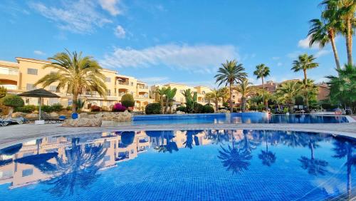 a large swimming pool with palm trees and buildings at CSS Cheerful Smart Superior 2BD Townhouse Limnaria Gardens in Paphos City