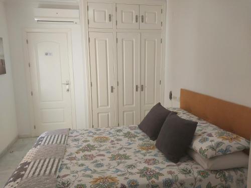 a bedroom with a bed with two pillows on it at Ático acogedor, céntrico y a 2 min de la playa. in Fuengirola