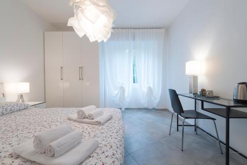 Habitación blanca con escritorio y cama en All'Abbazia, en Verona