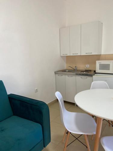 a living room with a white table and a blue couch at Montebello Inn apartments in Ulcinj