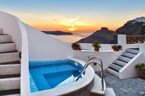 a swimming pool on a house with a sunset at Smaro Studios in Firostefani