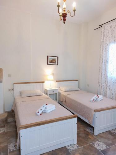 a bedroom with two beds and a chandelier at Iliaxtida Apartment in Agia Paraskevi