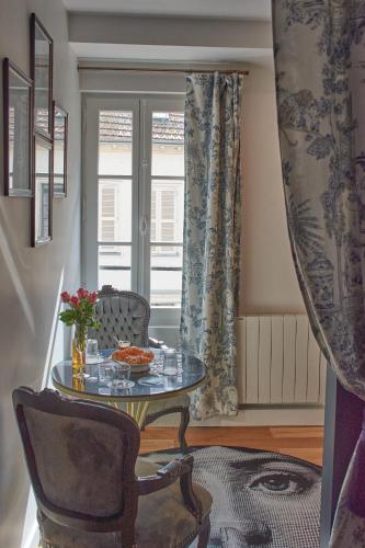une pièce avec une table, une chaise et une fenêtre dans l'établissement Le Boudoir, à Troyes