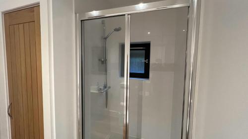 a shower with a glass door in a bathroom at NEW 1BD Contemporary Flat Upper Dunblane in Dunblane