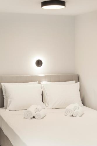 a white bed with towels on top of it at Loka Residence in Kavala