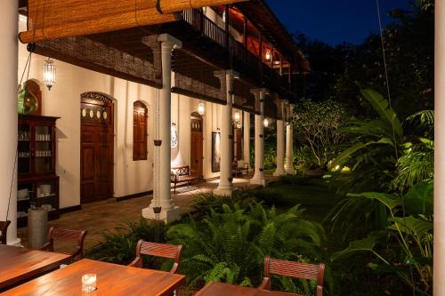 a restaurant with wooden tables and chairs in front of a building at Nyne Hotels Landesi - Galle Fort in Galle