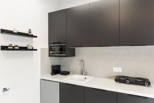 a kitchen with a sink and a microwave at Loka Residence in Kavala