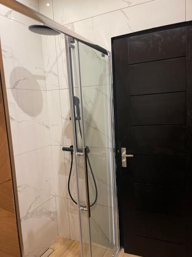 a shower with a glass door next to a wall at Boa vista appartementen in Paramaribo