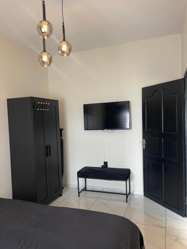 a bedroom with black furniture and a tv on the wall at Boa vista appartementen in Paramaribo