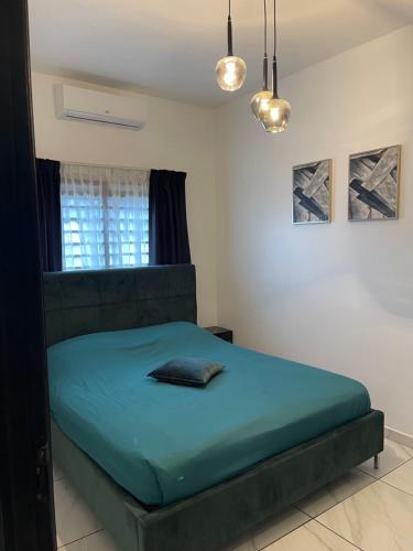 a bedroom with a bed with blue sheets and a window at Boa vista appartementen in Paramaribo